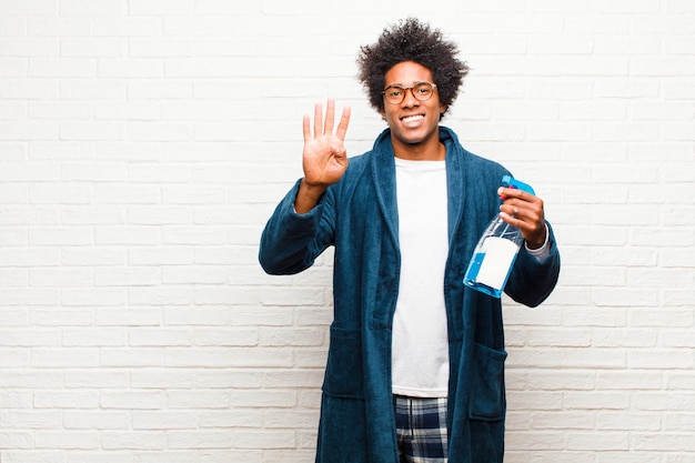 Young black man housekeeping with clean product