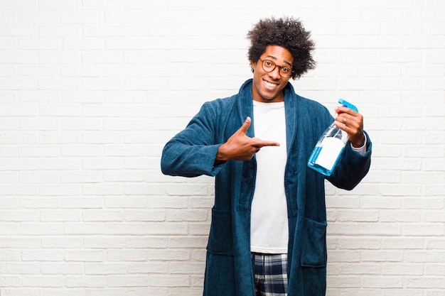 Young black man housekeeping with clean product