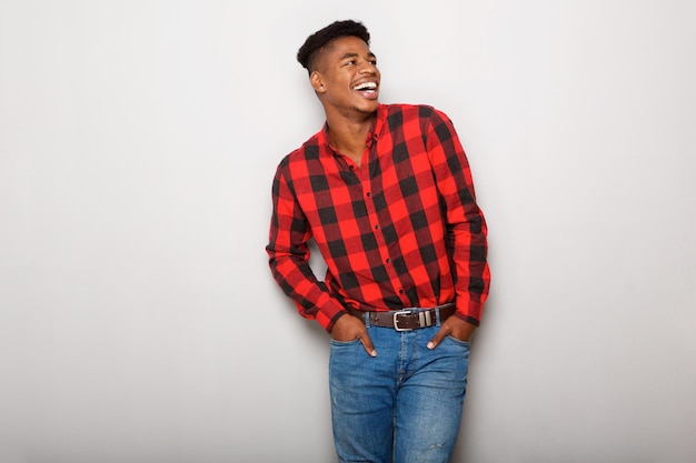 young black man laughing against gray background and looking away