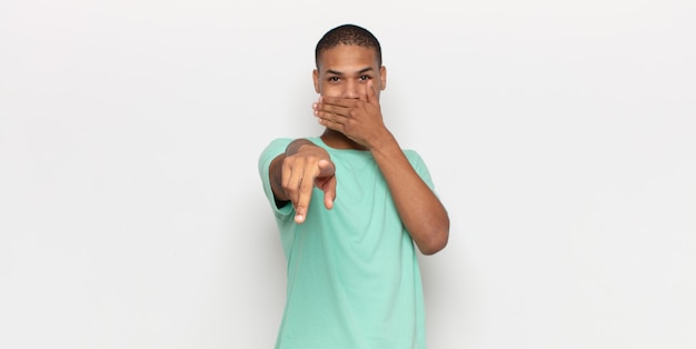 Young black man laughing at you, pointing to camera and making fun of or mocking you