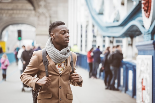 Young black man in London walking  on Tower Bridge