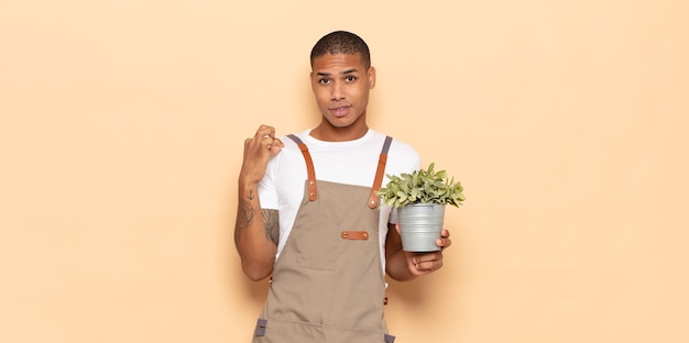 Young black man looking arrogant, successful, positive and proud, pointing to self