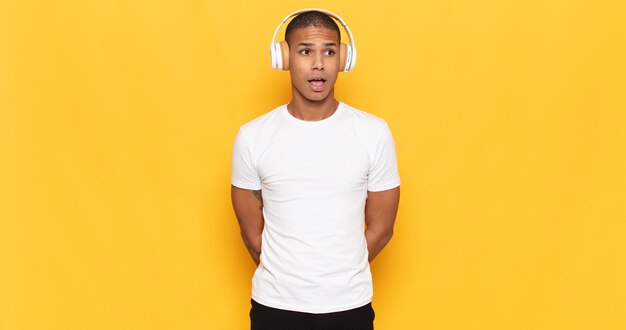 Young black man looking very shocked or surprised, staring with open mouth saying wow