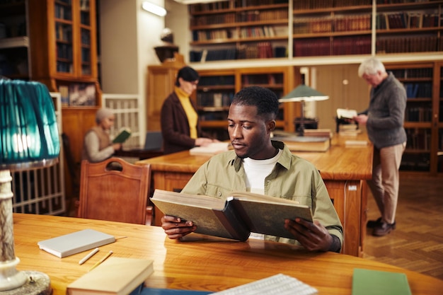 Young Black Man Reading in Library