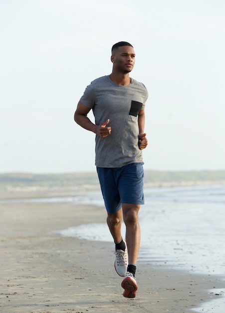 Photo young black man running on beach