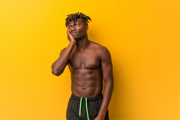 Young black man shirtless wearing swimsuit who is bored, fatigued and need a relax day.