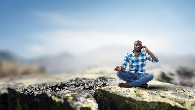 Young black man sitting and meditating. Mixed media