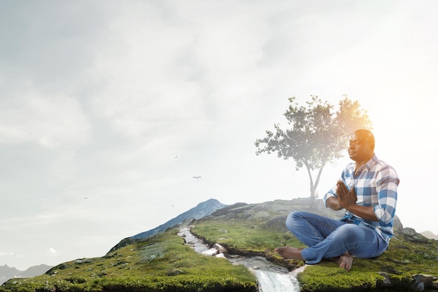 Young black man sitting and meditating. Mixed media