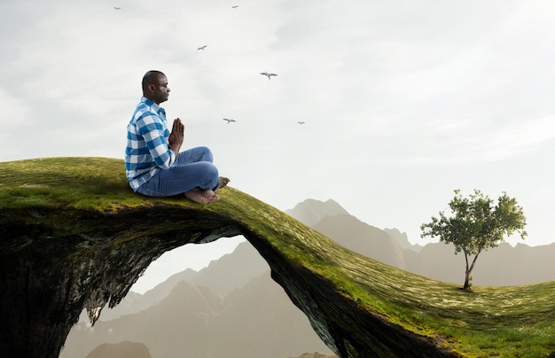 Young black man sitting and meditating. Mixed media