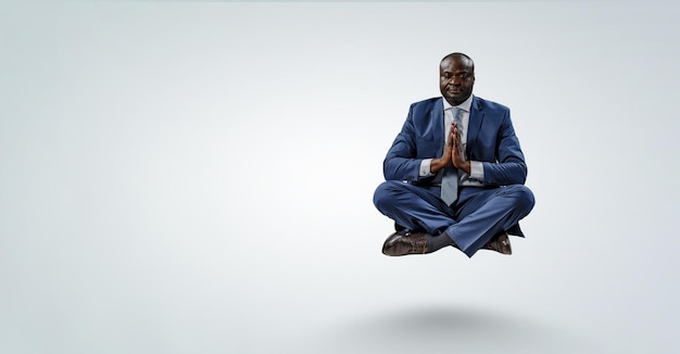 Молодой темнокожий мужчина сидит и медитирует. Смешанная техника