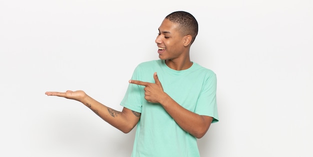 Young black man smiling, feeling happy