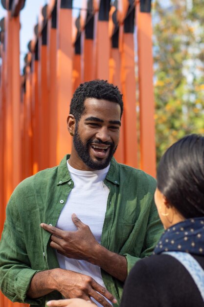 Young black man talking with an unrecognizable woman on the street