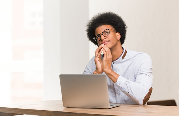 Young black man using his laptop devising a plan