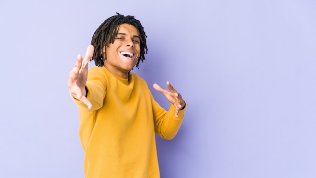 Young black man wearing rasta hairstyle feels confident giving a hug