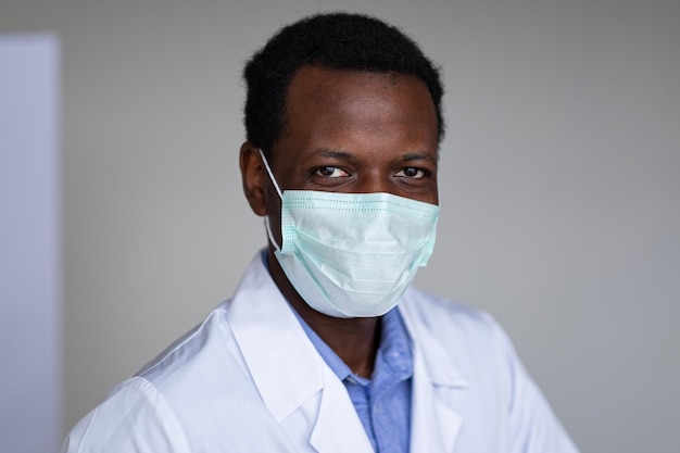 Young black man wearing a white coat and face mask portrait