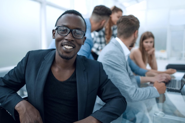 Young black man with colleagues in the office at the table