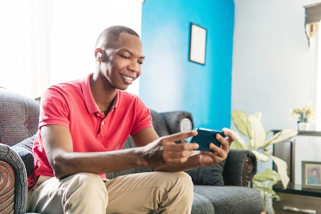 Young black man with earphones watching a movie on the phone Streaming concept