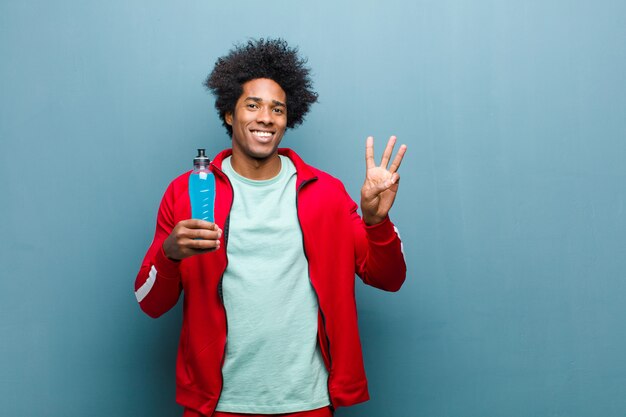 Молодой черный человек со спортивным напитком
