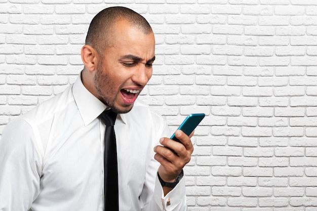 Young and black man yelling at the cellphone