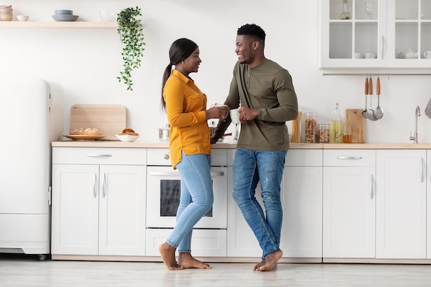 自宅のキッチンで一緒に時間を過ごす若い黒人夫婦