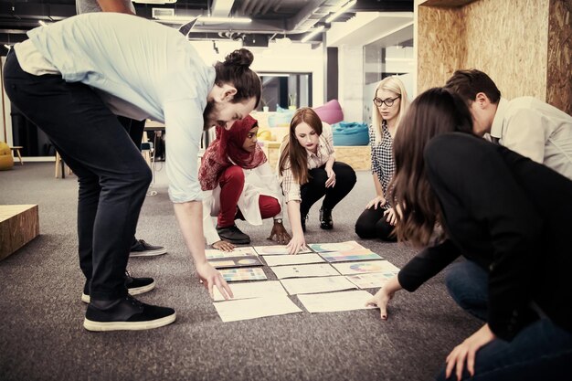 young black muslim businesswoman having meeting with her multiethnic startup business team in modern office interior,presenting new ideas on the floor