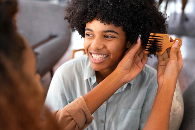 Foto giovane persona di colore che si prende cura dei capelli afro