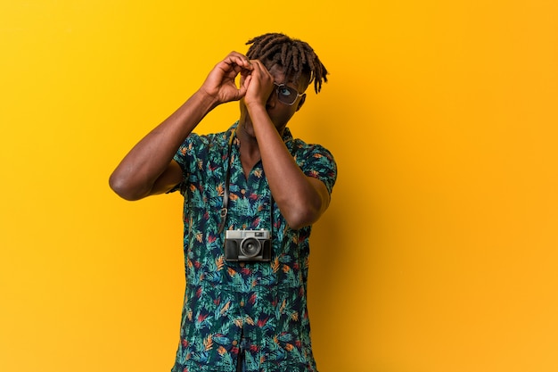 Young black rasta man wearing a vacation look looking far away keeping him hand on forehead.