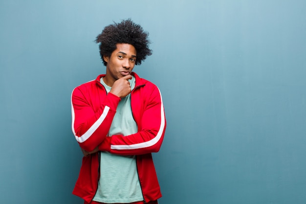 Young black sports man looking serious, confused, uncertain and thoughtful, doubting among options or choices