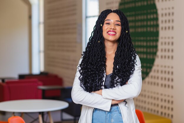 Photo young black woman brazilian university student in college hallway smiling dressed in white