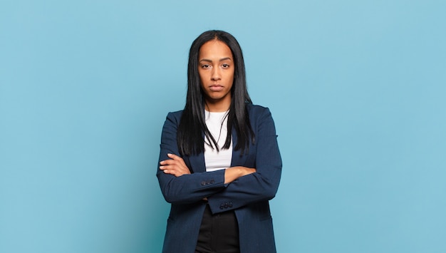 Young black woman feeling displeased and disappointed, looking serious, annoyed and angry with crossed arms. business concept