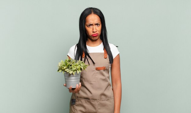 Young black woman feeling sad and whiney with an unhappy look, crying with a negative and frustrated attitude. gardener concept