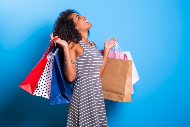 Young black woman holding shopping bags  