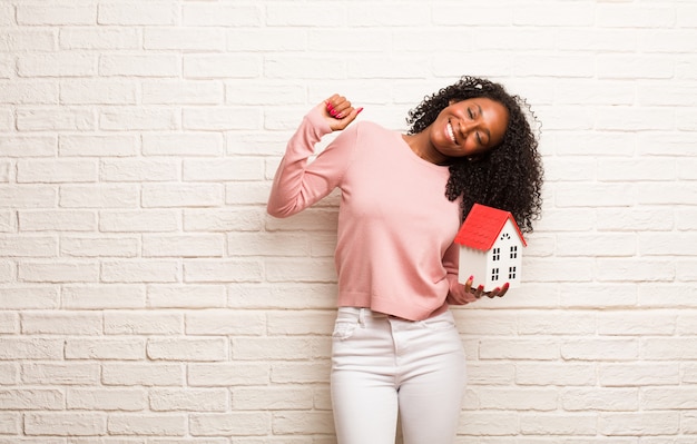 Young black woman Listening to music, dancing and having fun, moving, shouting and expressing happiness, freedom concept