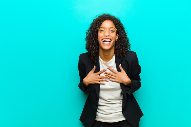Young black woman looking happy, surprised, proud and excited, pointing to self