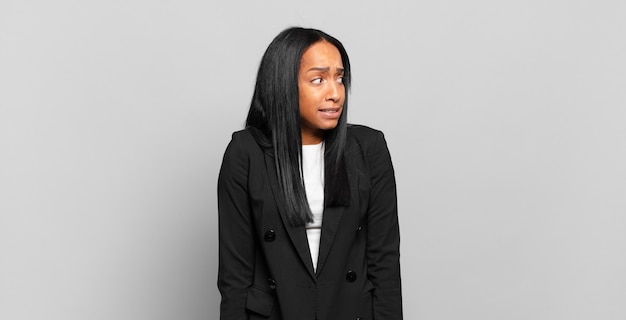 Photo young black woman looking worried, stressed, anxious and scared, panicking and clenching teeth. business concept