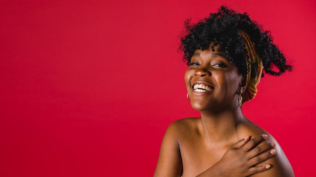 Young black woman toothy smiling with naked shoulders