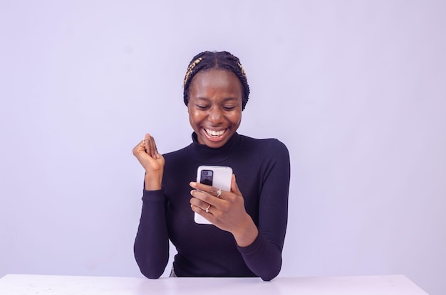 Young black woman using her phone with a smiling