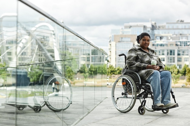 Photo young black woman in wheelchair urban city setting