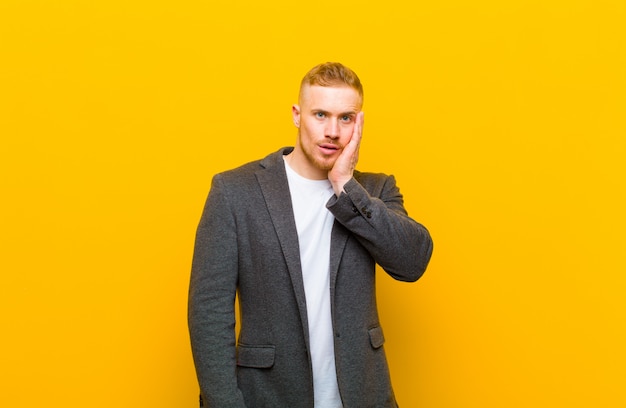 Young blond businessman feeling shocked