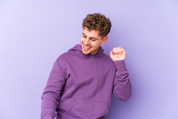 Young blond curly hair caucasian man dancing and having fun.