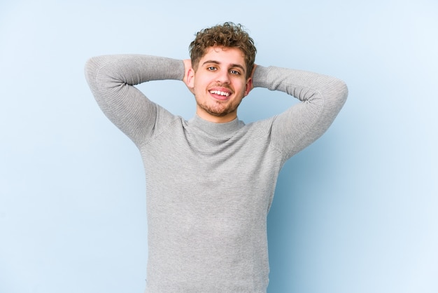 Young blond curly hair caucasian man isolated feeling confident, with hands behind the head.