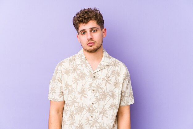 Young blond curly hair caucasian man isolated sad, serious face, feeling miserable and displeased.