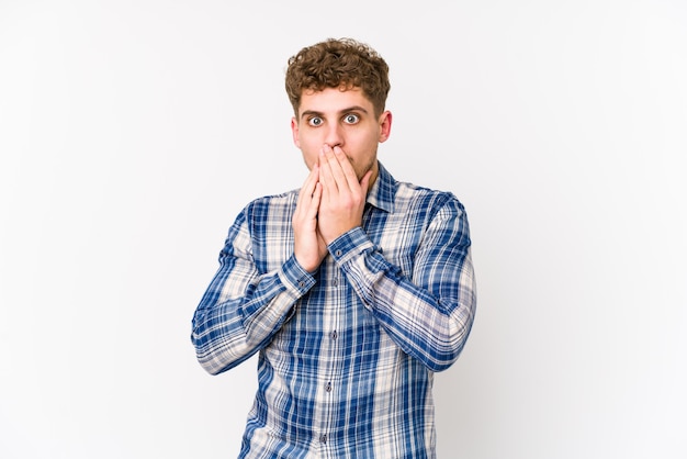 Young blond curly hair caucasian man isolated shocked covering mouth with hands.