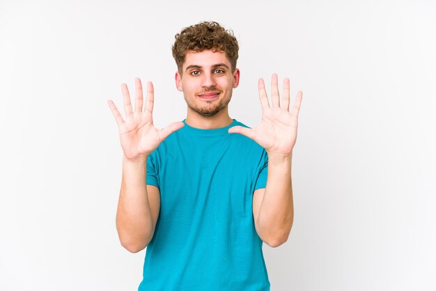 Young blond curly hair caucasian man isolated showing number ten with hands.