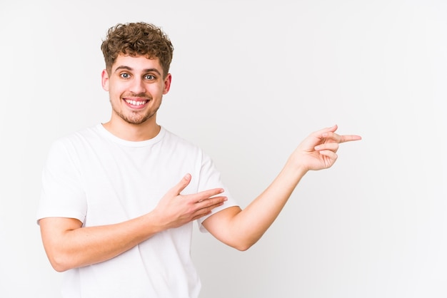 L'uomo caucasico dei giovani capelli ricci biondi ha isolato sorridendo allegramente indicando con l'indice via.