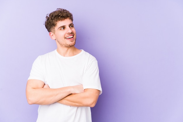 Young blond curly hair caucasian man isolated smiling confident with crossed arms.