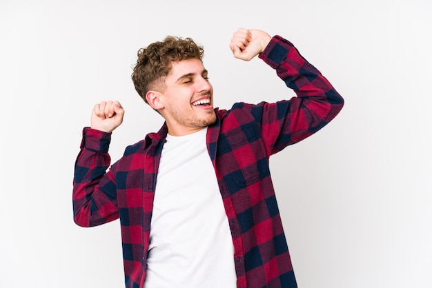 Young blond curly hair caucasian man isolated stretching arms, relaxed position.