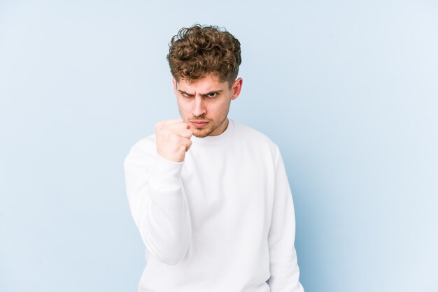 Young blond curly hair caucasian man showing fist