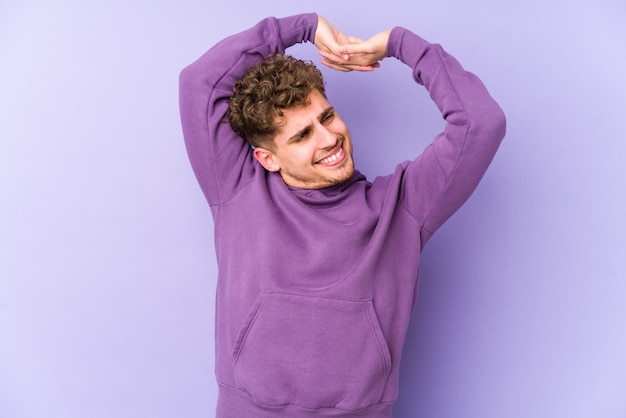 Young blond curly hair caucasian man stretching arms, relaxed position.