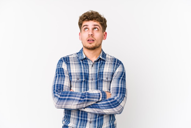 Young blond curly hair caucasian man tired of a repetitive task.